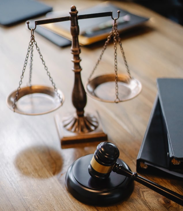 Scales on wooden desk with gavel next to them