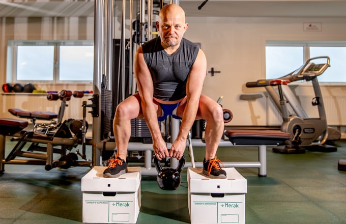Athlete stands on two Merak archive boxes to show how strong they are