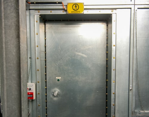 Een geel bordje van argonite hangt boven de deur in de e-bunker