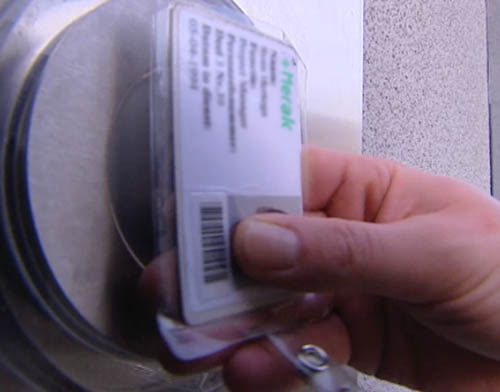 Een persoon scant een plastic toegangsbewijs met barcode.