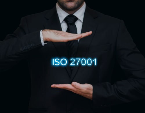 Gros plan sur un homme en costume, le mot ISO 9001 flottant entre ses mains