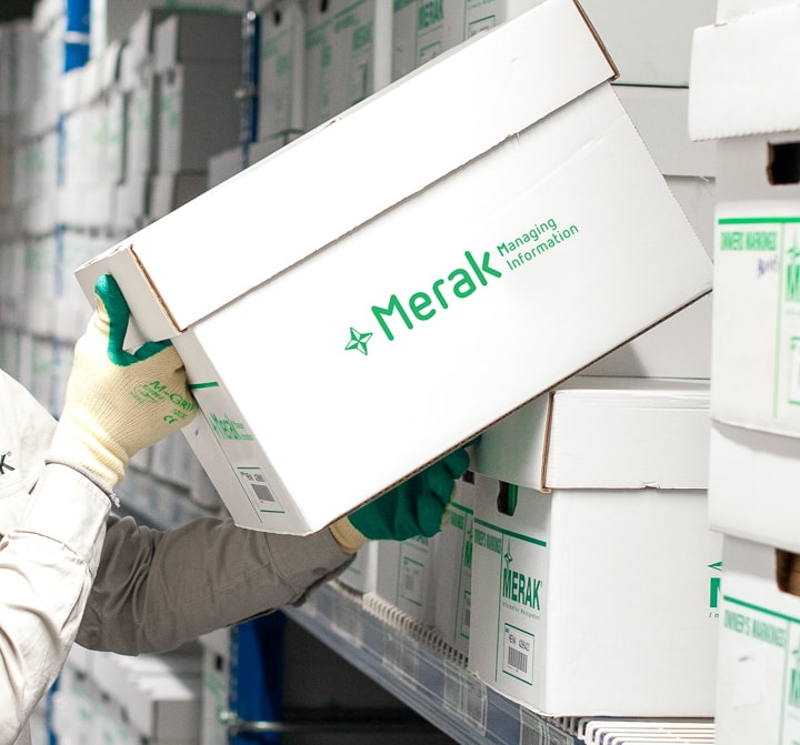 Une boîte d'archives Merak est retirée des étagères par un employé