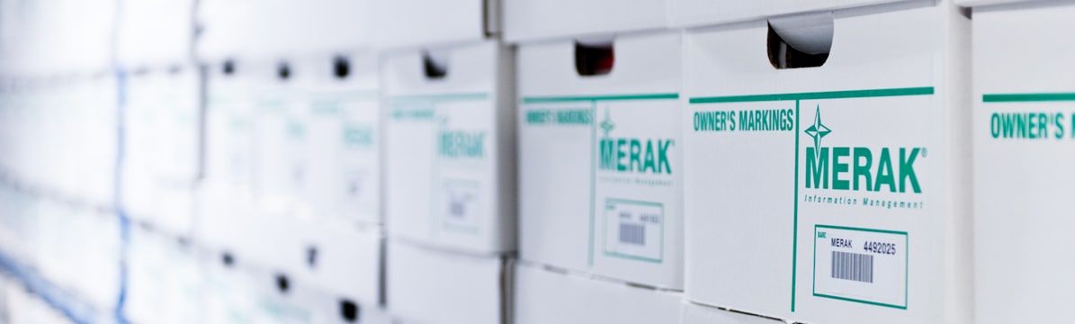 Stacked Merak archive boxes form a wall