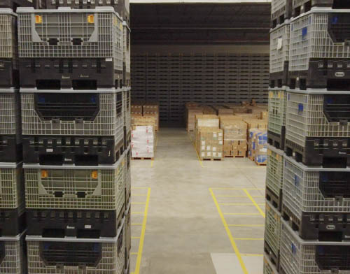 Un espace de stockage rempli de caisses empilées, montrant un espace de stockage organisé.