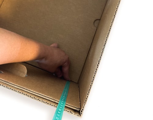 Green tape measure held against the inside of a box