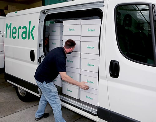 Courier from Merak loading van with archive boxes
