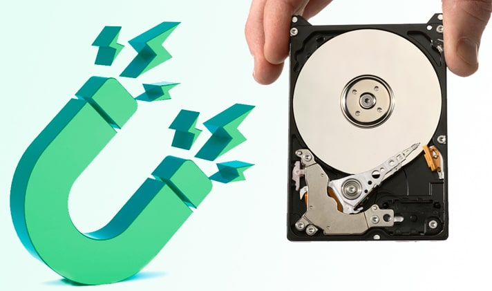 An illustration of a green magnet with next to it an image of a hand holding a hard disk