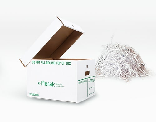 A white cardboard filing box with a pile of paper shreds behind it